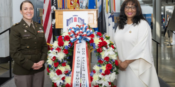 Congresswoman Bynum presenting a service member with a wreath at a wreath laying ceremony at the Arlington National Cemetery.