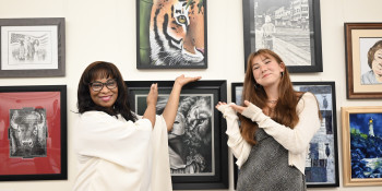 Congresswoman Bynum stands with Congressional Art Competition winner Ren Suo next to Ren's painting of a tiger. 
